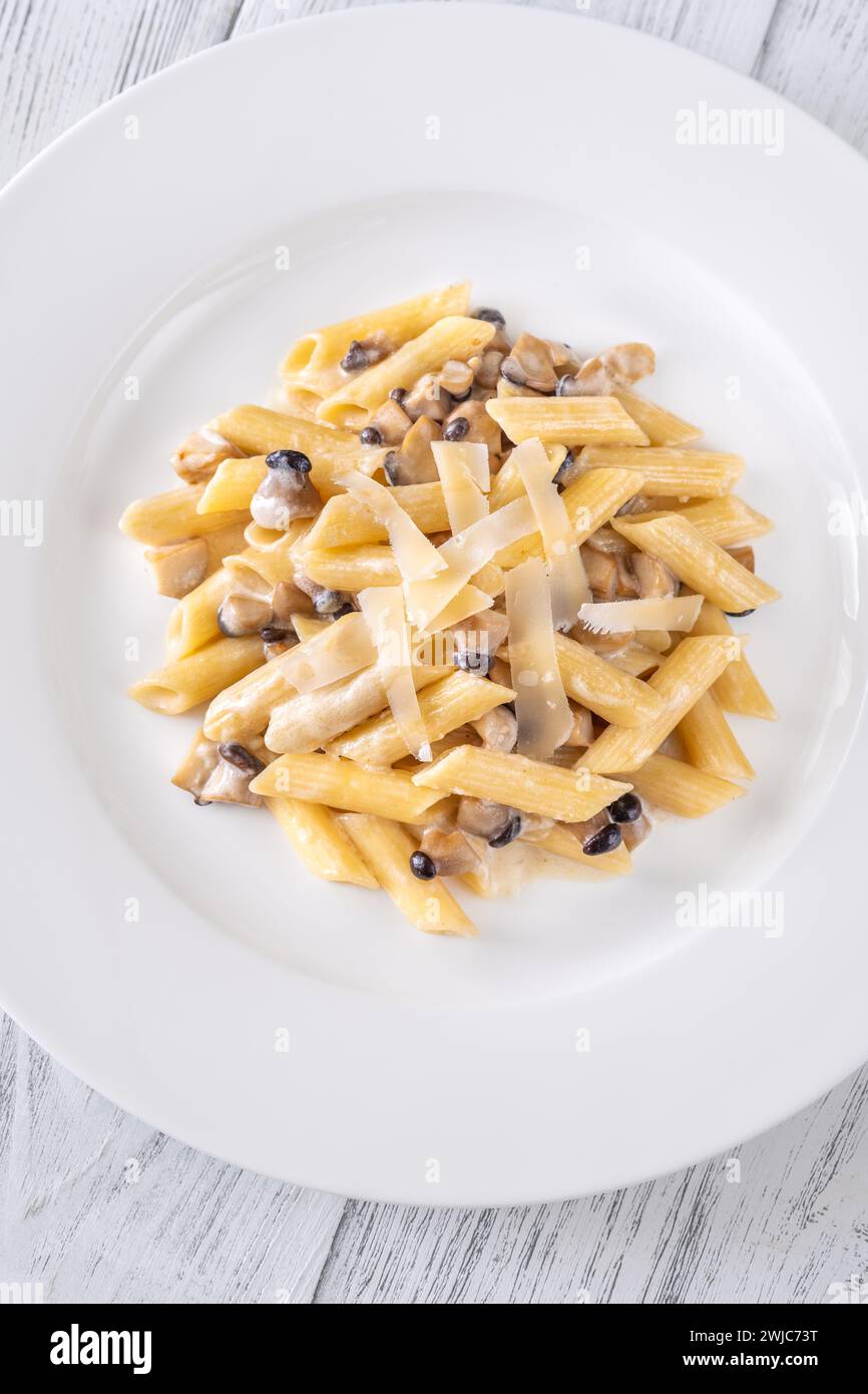 Portion of creamy garlic penne pasta with mushroom Stock Photo