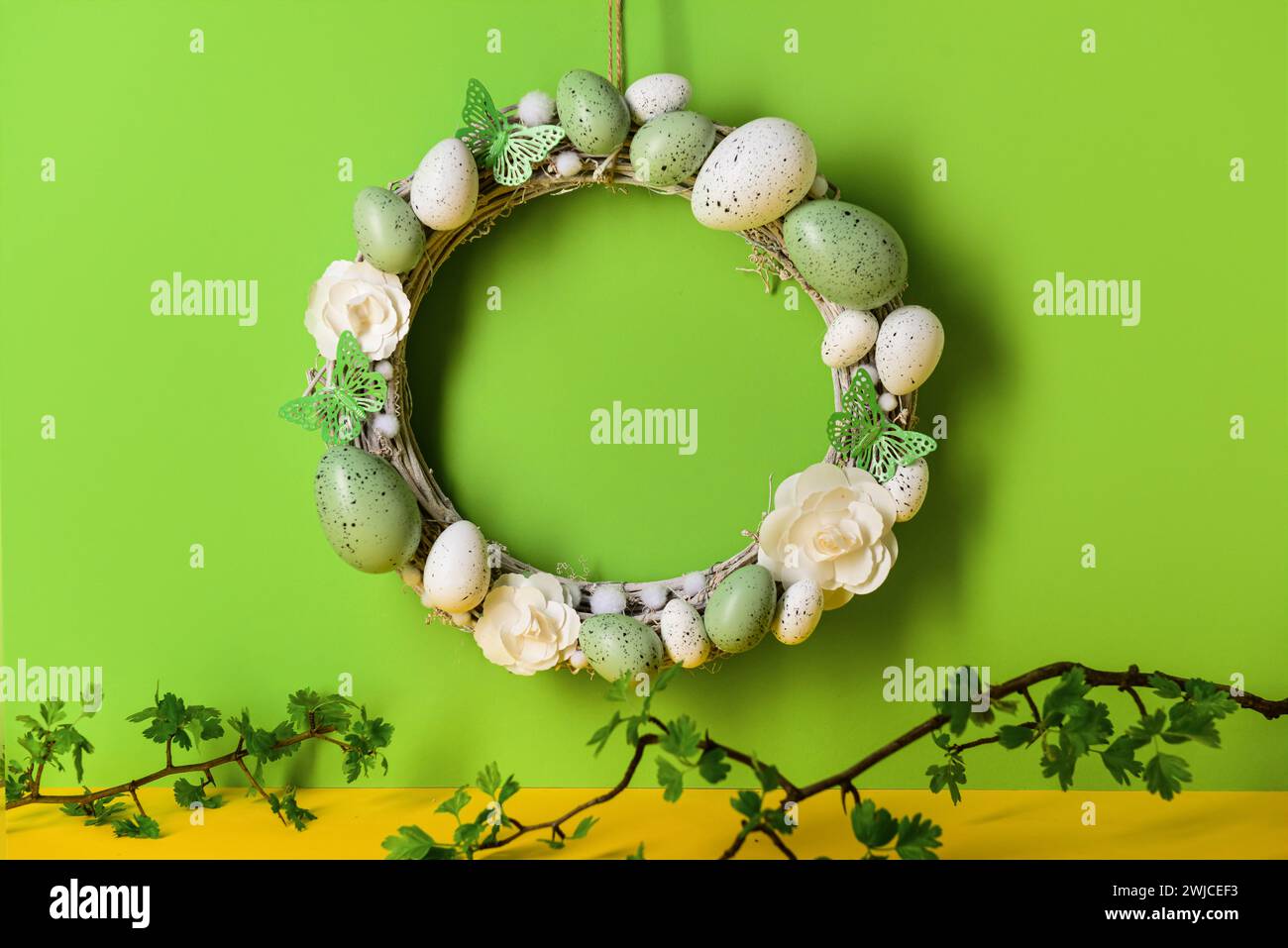 Easter wreath made of flowers, eggs and butterflies with branches ...