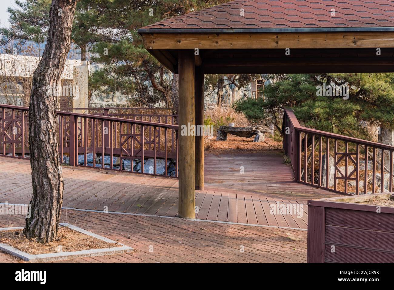 Wooden covered walkway and railings in neglected public park on winter ...