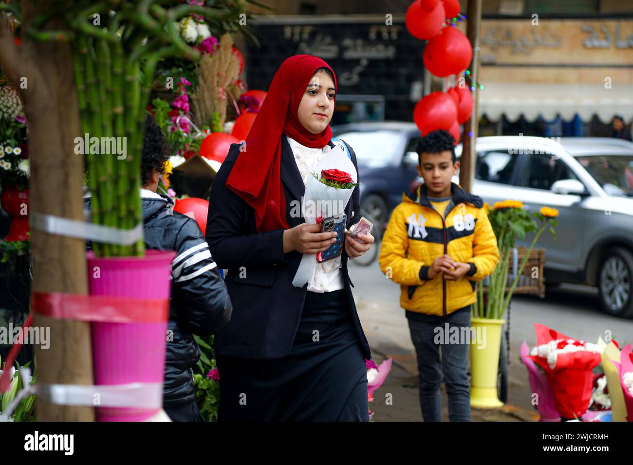 Cairo, Egypt. 14th Feb, 2024. A woman holds a flower on Valentine's Day