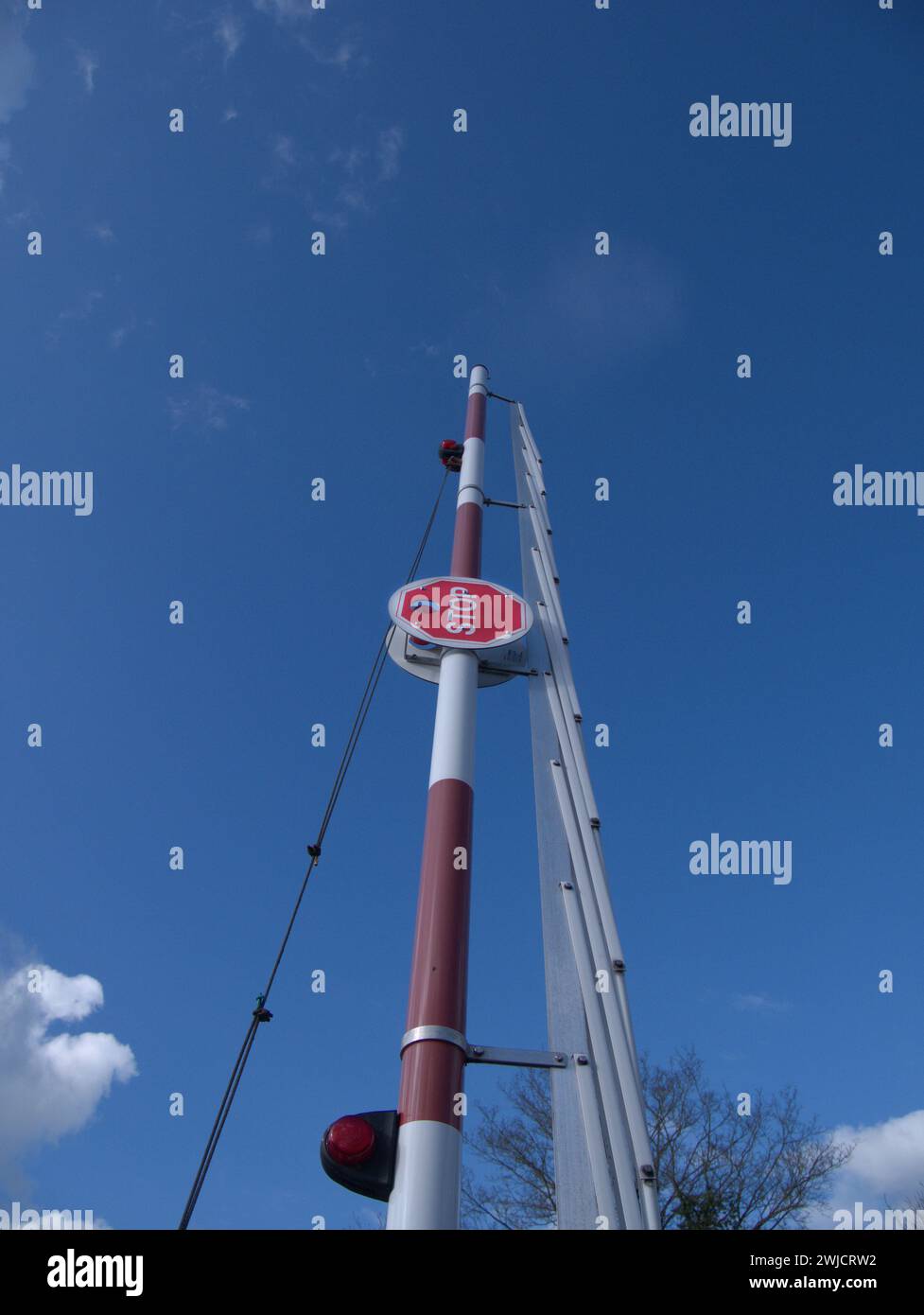 Raised barrier with stop sign against a blue sky Stock Photo - Alamy