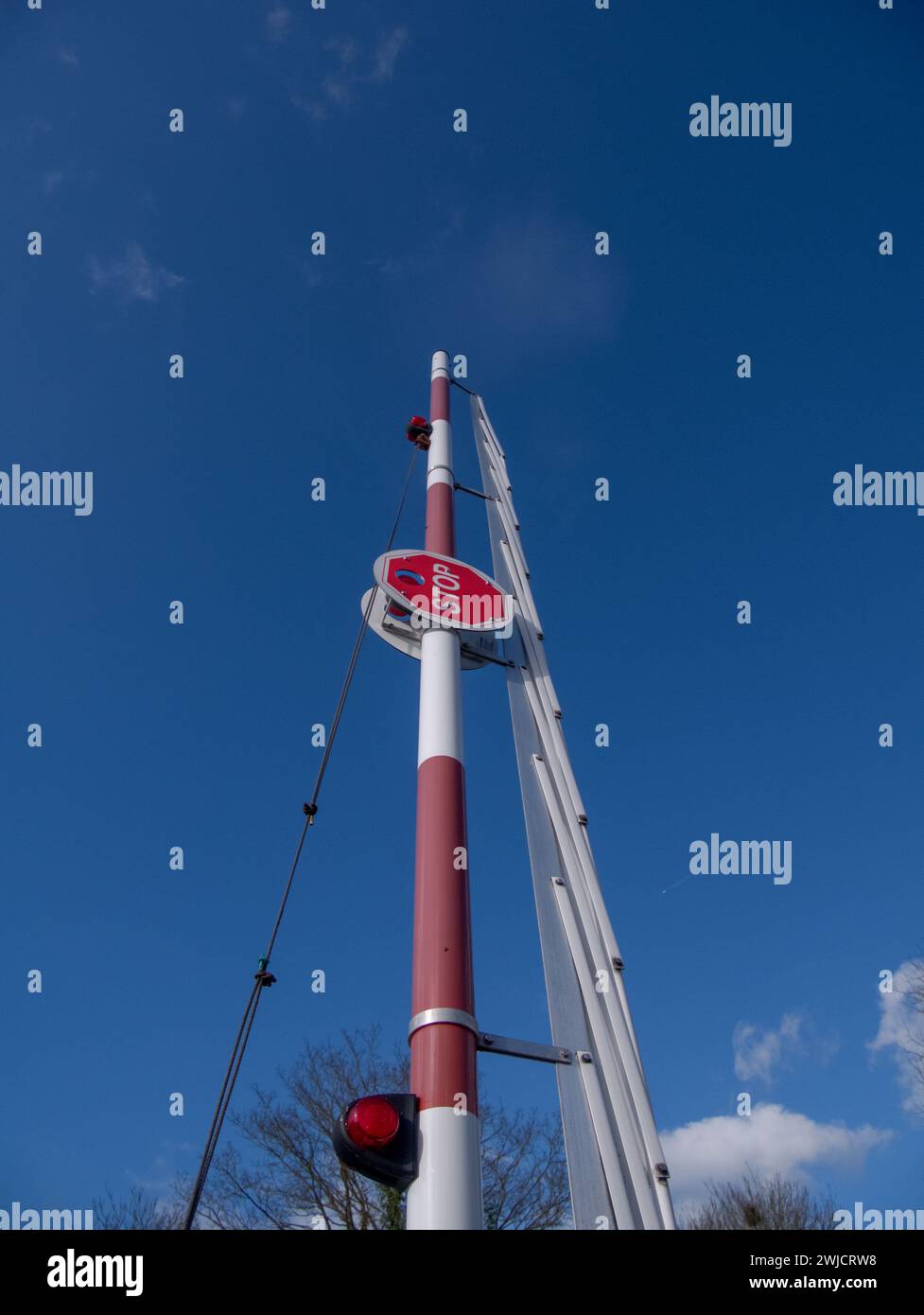 Raised barrier with stop sign against a blue sky Stock Photo - Alamy