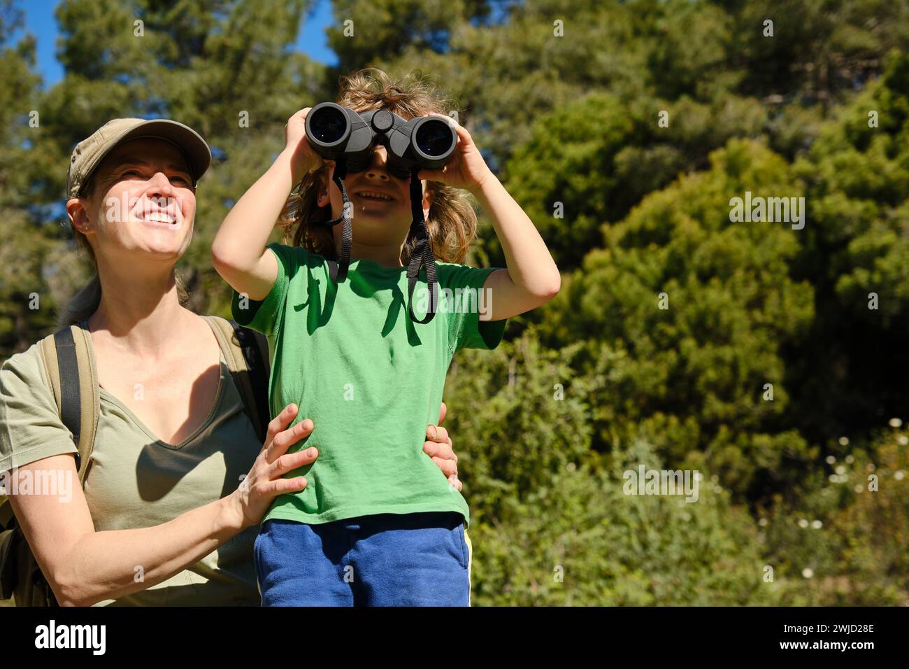 Mother and son using binoculars in nature Stock Photo