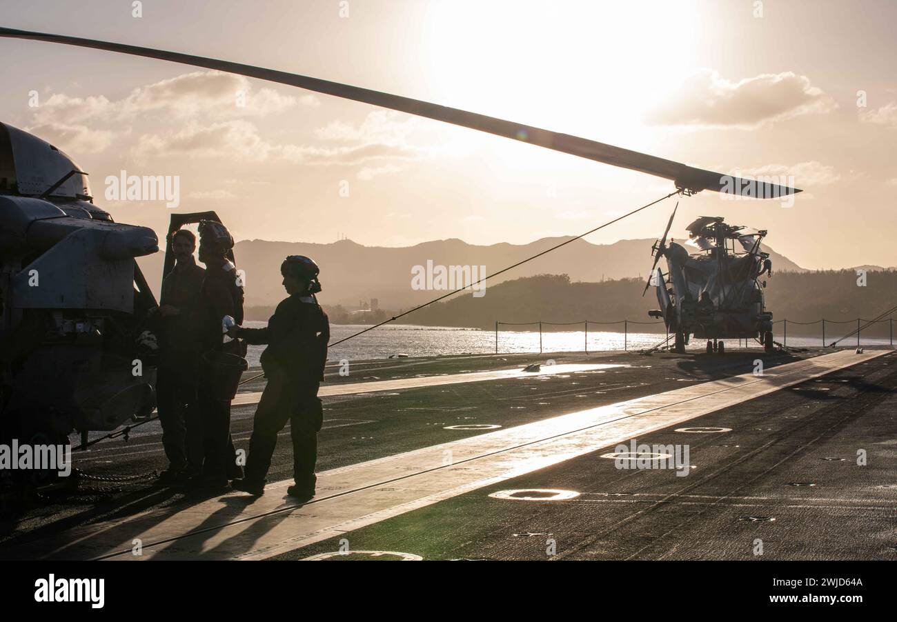 APRA HARBOR, Guam (Feb. 14, 2024) U.S. Sailors conduct maintenance on an MH-60R Sea Hawk, assigned to the “Wolf Pack” of Helicopter Maritime Strike Squadron (HSM) 75, aboard the Nimitz-class aircraft carrier USS Theodore Roosevelt (CVN 71), Feb. 14, 2024. Theodore Roosevelt, flagship of Carrier Strike Group Nine, is currently pier side in Apra Harbor, Guam, for a scheduled port visit. An integral part of U.S. Pacific Fleet, U.S. 7th Fleet operates naval forces in the Indo-Pacific and provides the realistic, relevant training necessary to execute the U.S. Navy’s role across the full spectrum of Stock Photo