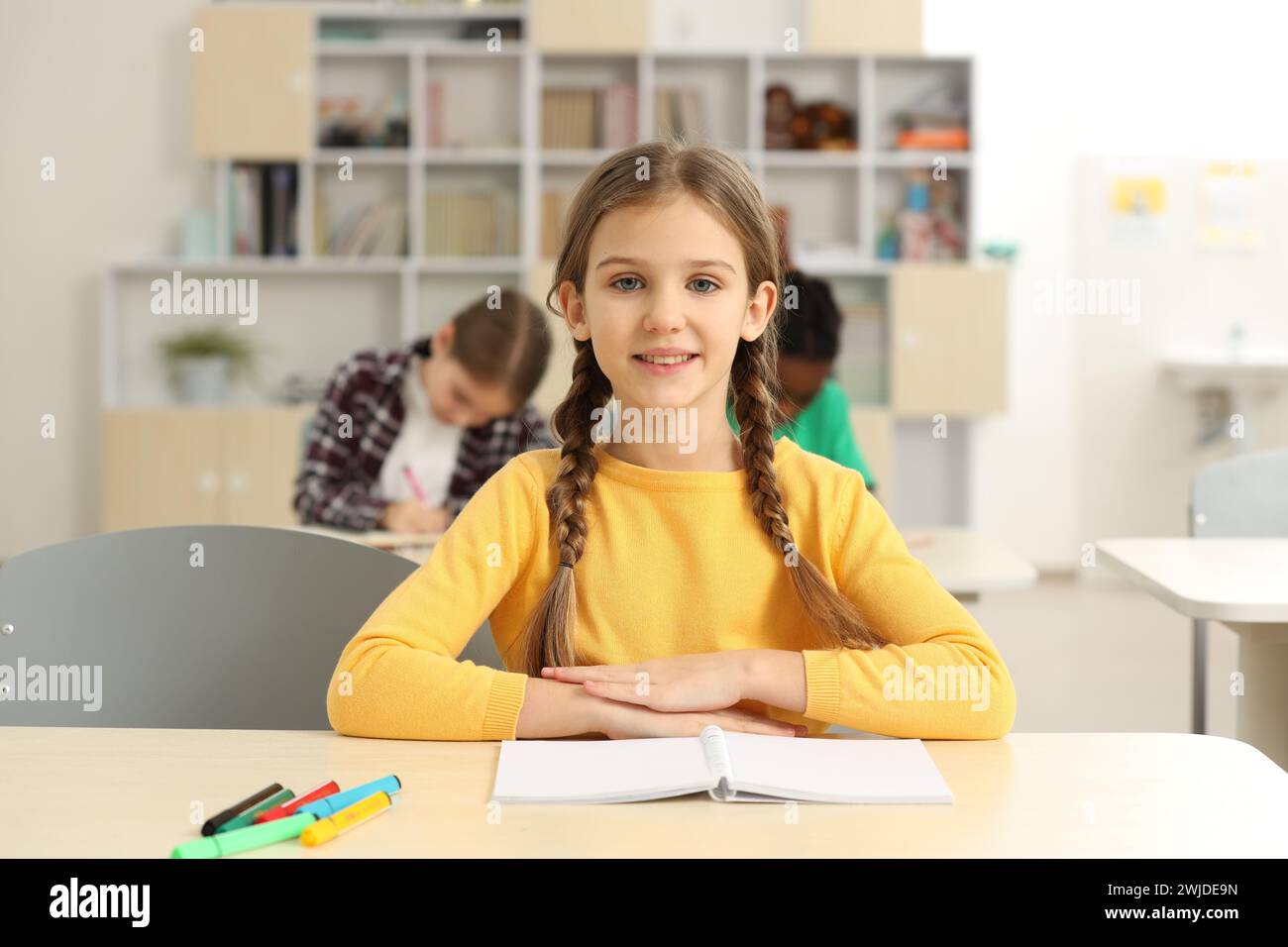 Portrait of smiling little girl studying in classroom at school Stock ...