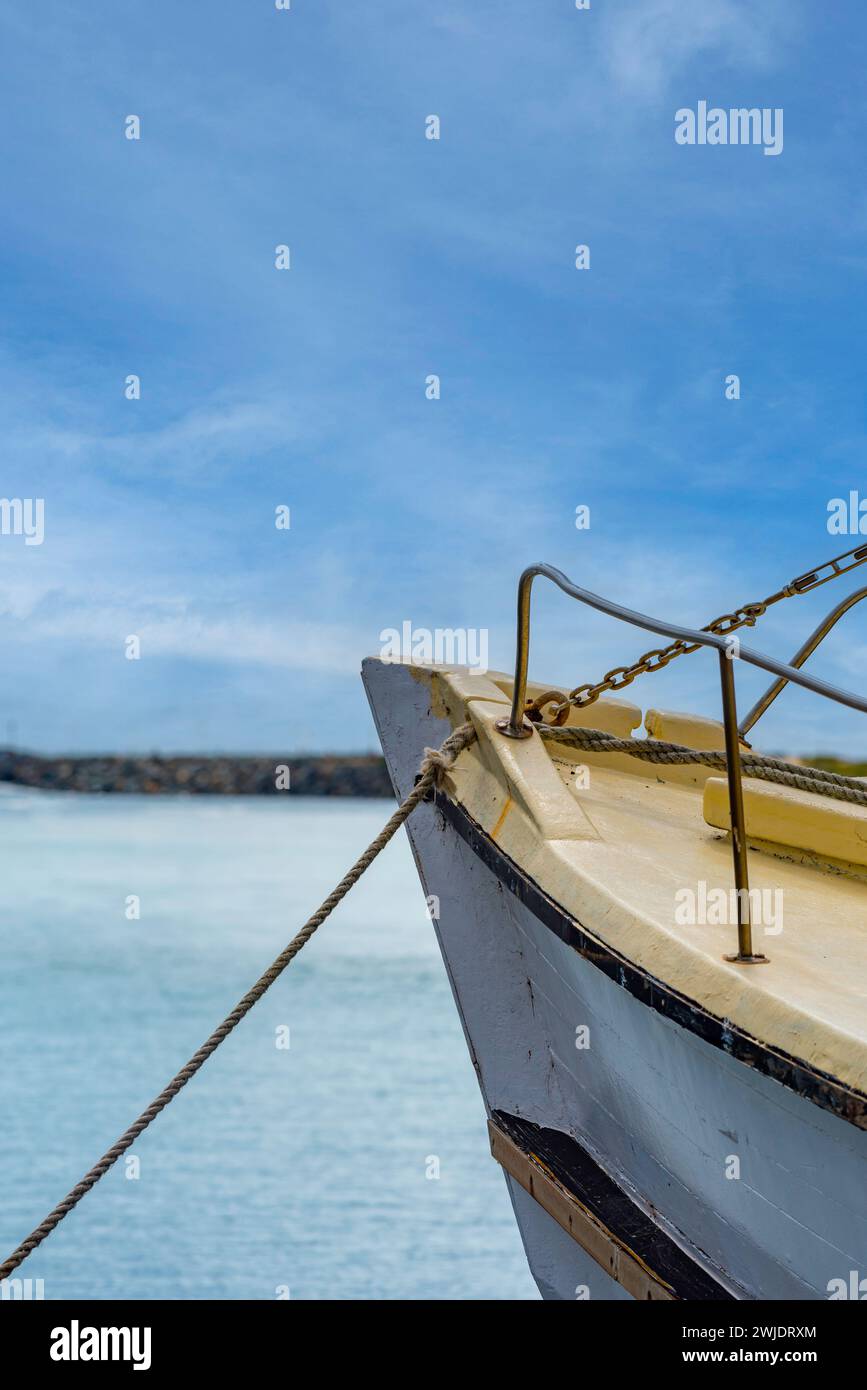 The bow or foredeck area and a mooring rope of an older timber fishing boat inside the breakwater at Forster Tuncurry, New South Wales, Australia Stock Photo