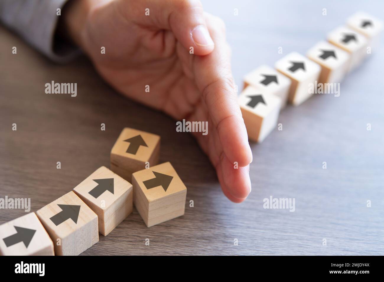 Wooden blocks with arrow and hand. Delays and disruptions, stop the process, critical error concept Stock Photo