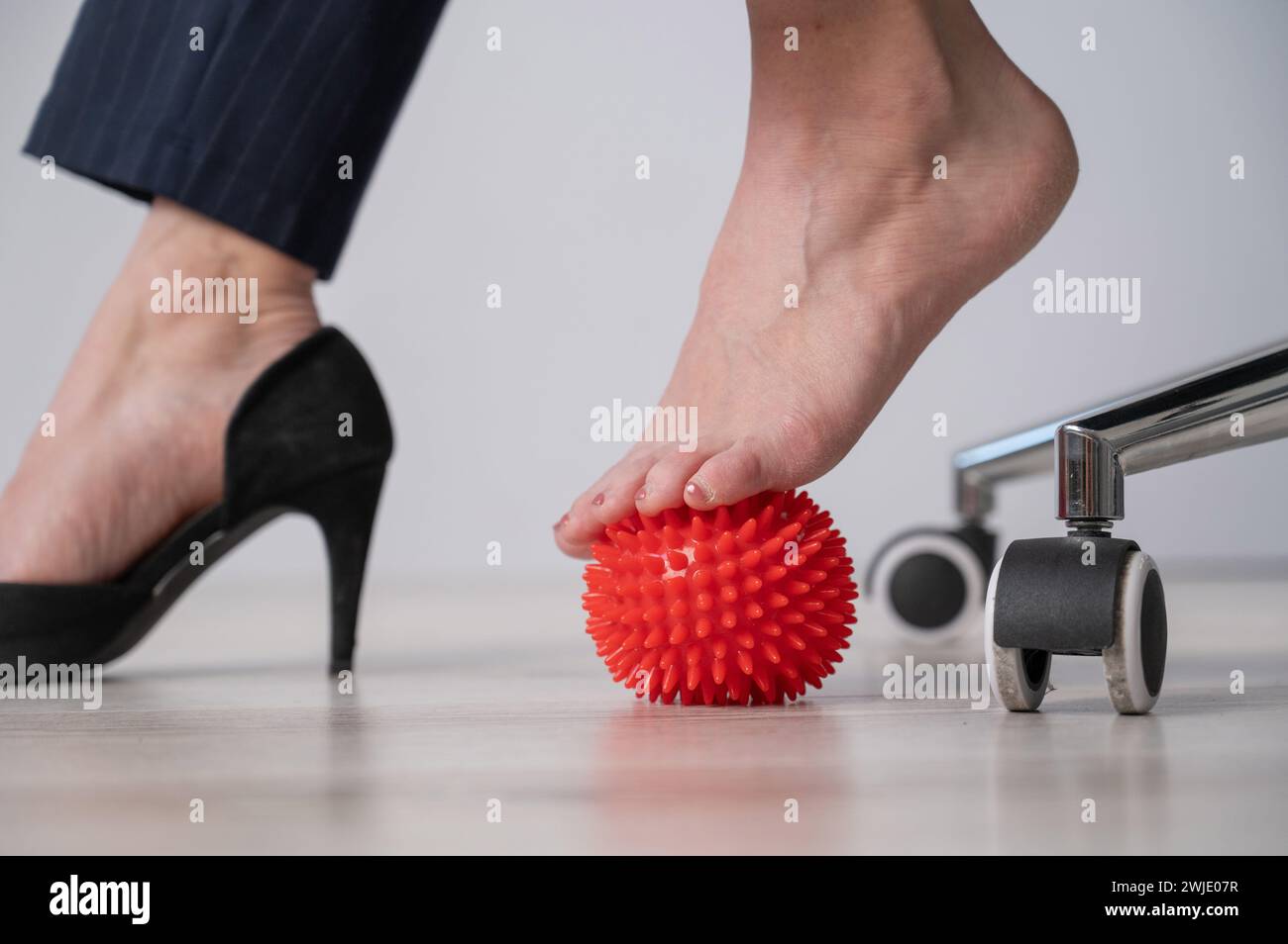 Business woman massages her feet on a massage ball with spikes Stock ...