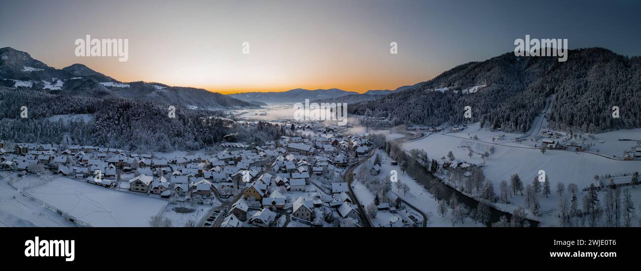 Beautiful village of Ljubno ob Savinji, home of female ski jump competition. Winter panorama from above the village in early morning. Sun rising over Stock Photo