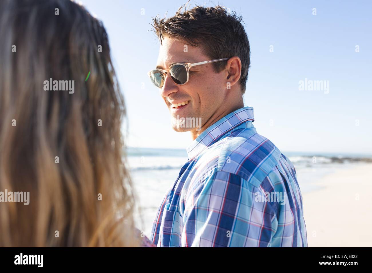 Caucasian couple enjoys a sunny beach day Stock Photo