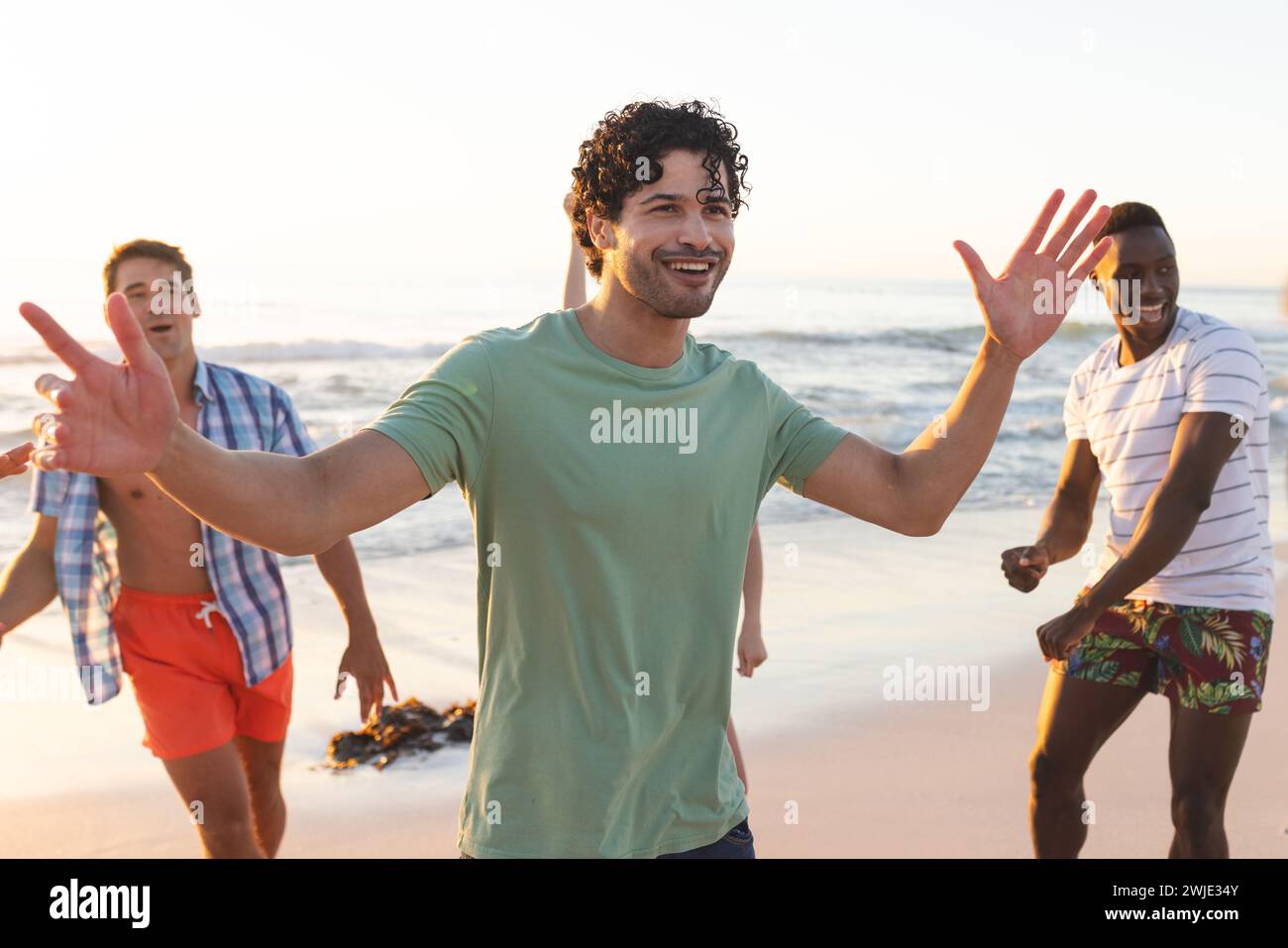 Young men enjoy a lively game on the beach Stock Photo
