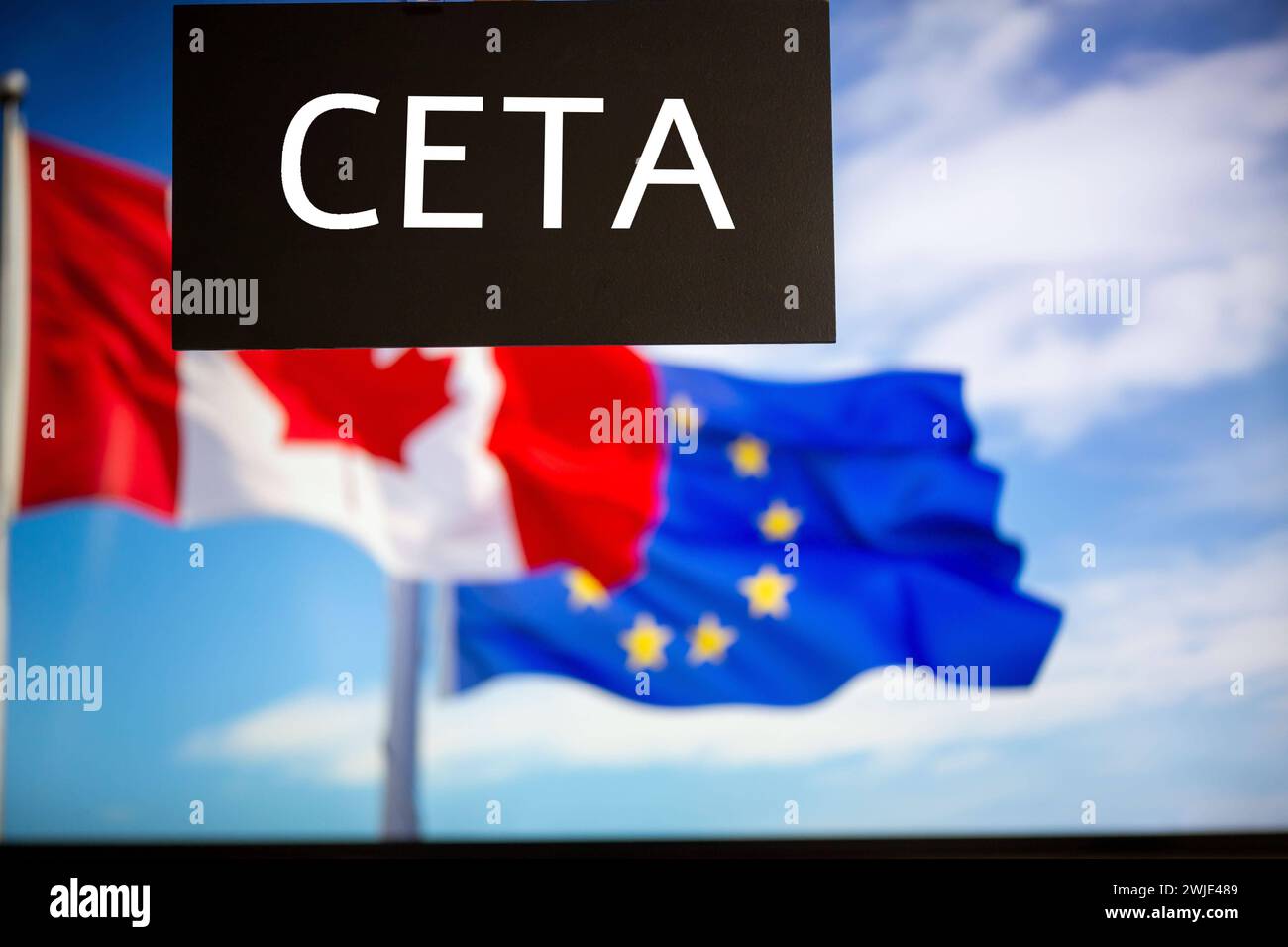 Schild mit der Aufschrift CETA vor den Flaggen von Kanada und der Europäischen Union. Die Abkürzung CETA steht für ein Freihandelsabkommen zwischen den beiden Partnern *** Sign with the inscription CETA in front of the flags of Canada and the European Union The abbreviation CETA stands for a free trade agreement between the two partners Copyright: xx Stock Photo