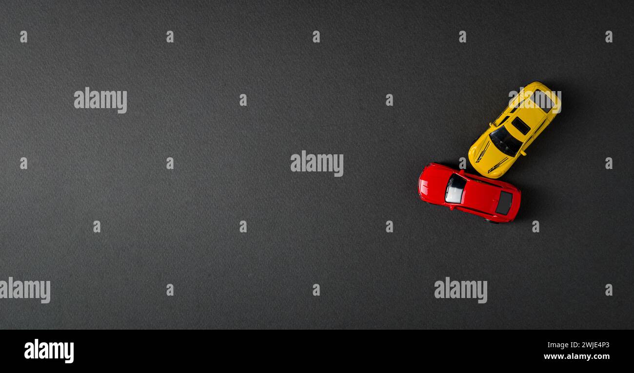 Top view of red and yellow cars colliding and crashing on dark gray background Stock Photo