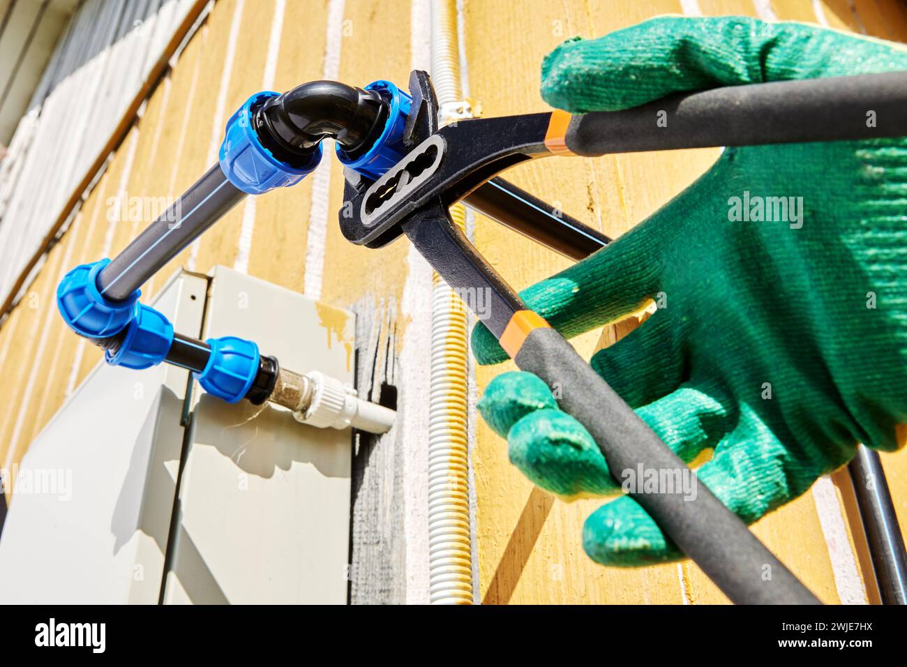 Tighten compression clamp nut of elbow fitting for joint plastic pipes