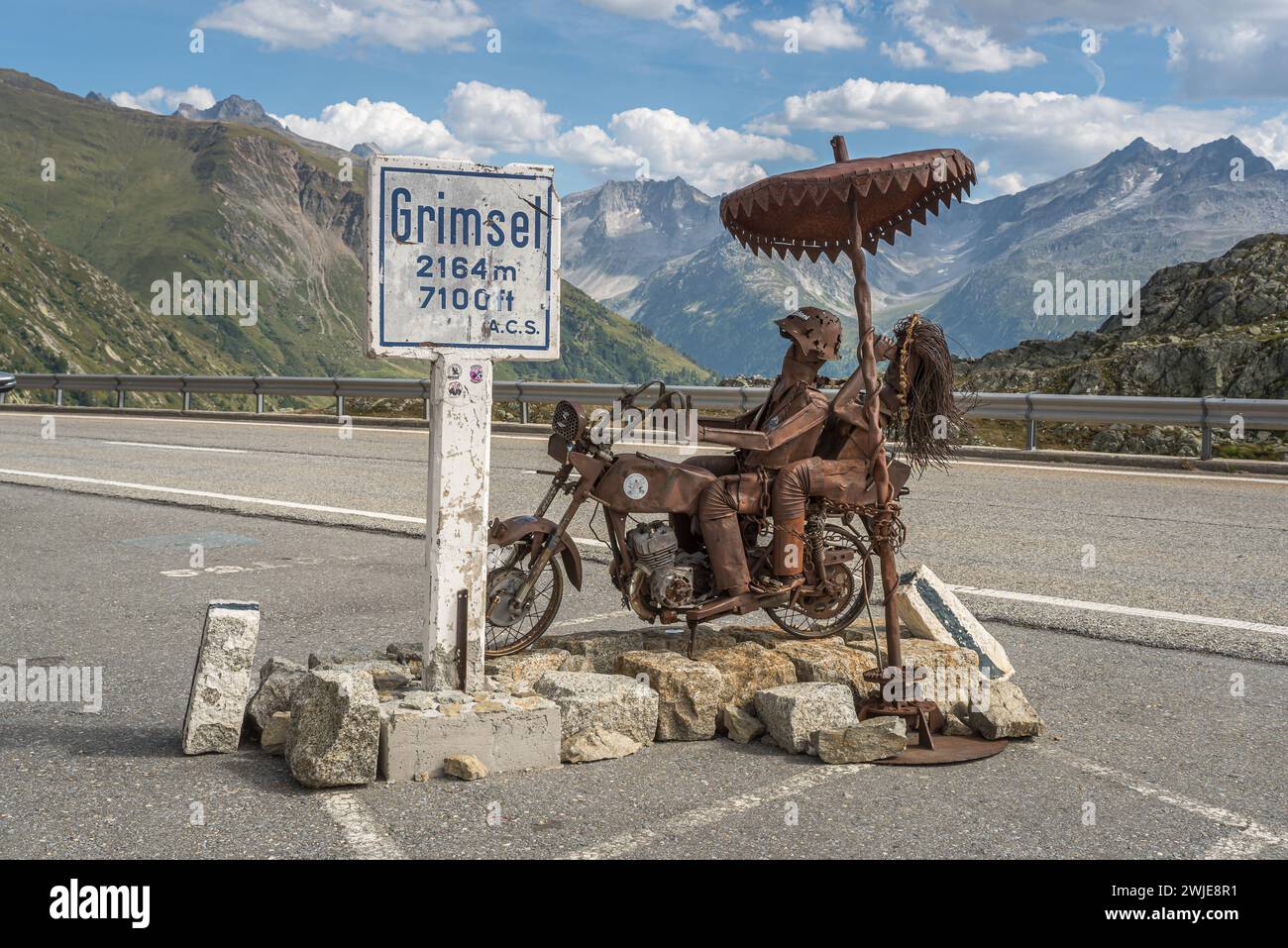 Grimsel Pass, metal sculpture of a biker couple and sign with altitude information at the t Stock Photo