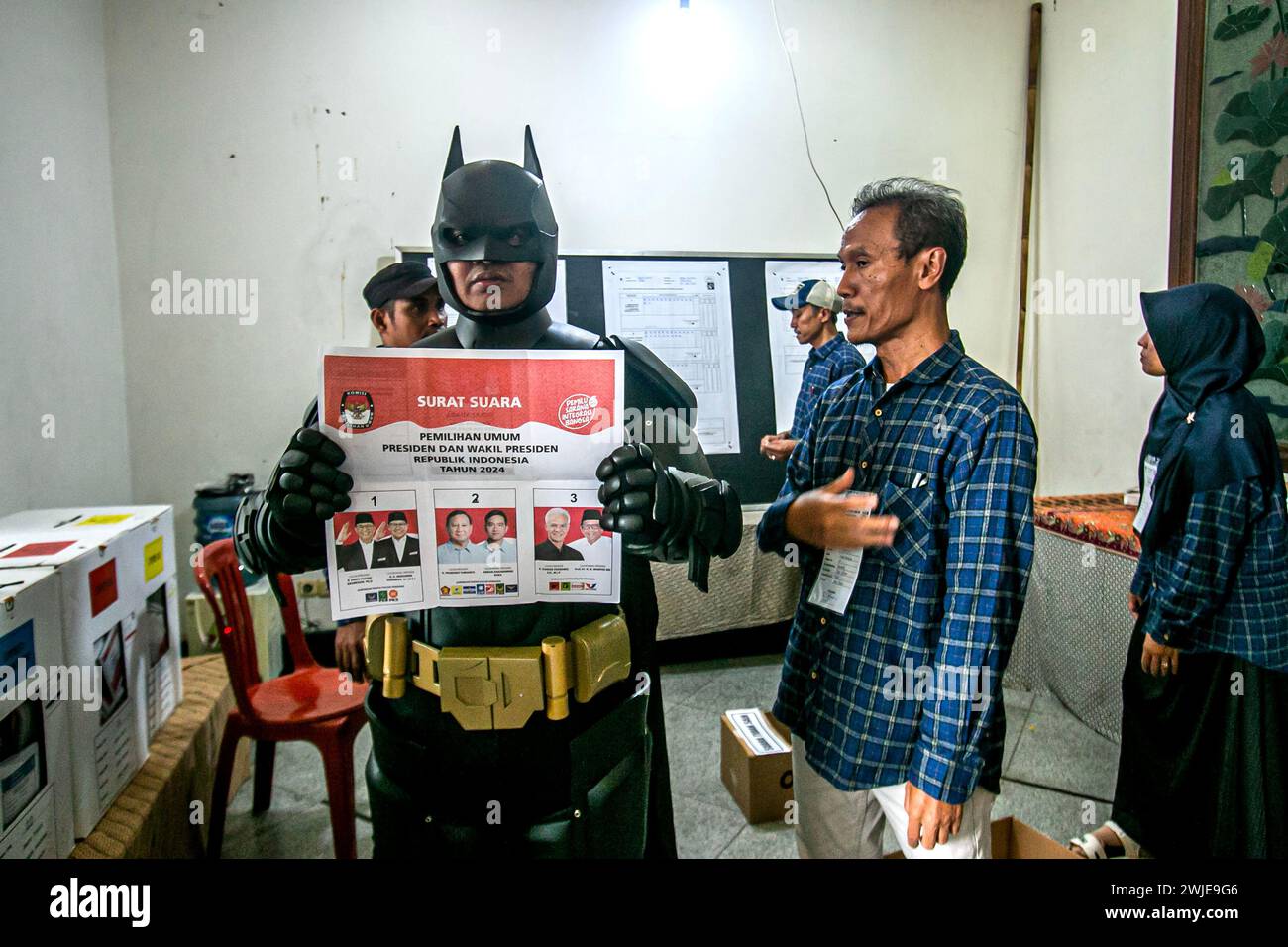 An election official wearing a Batman costume works during Indonesia presidential at a polling station in Bogor, Indonesia on February 14, 2024 Stock Photo