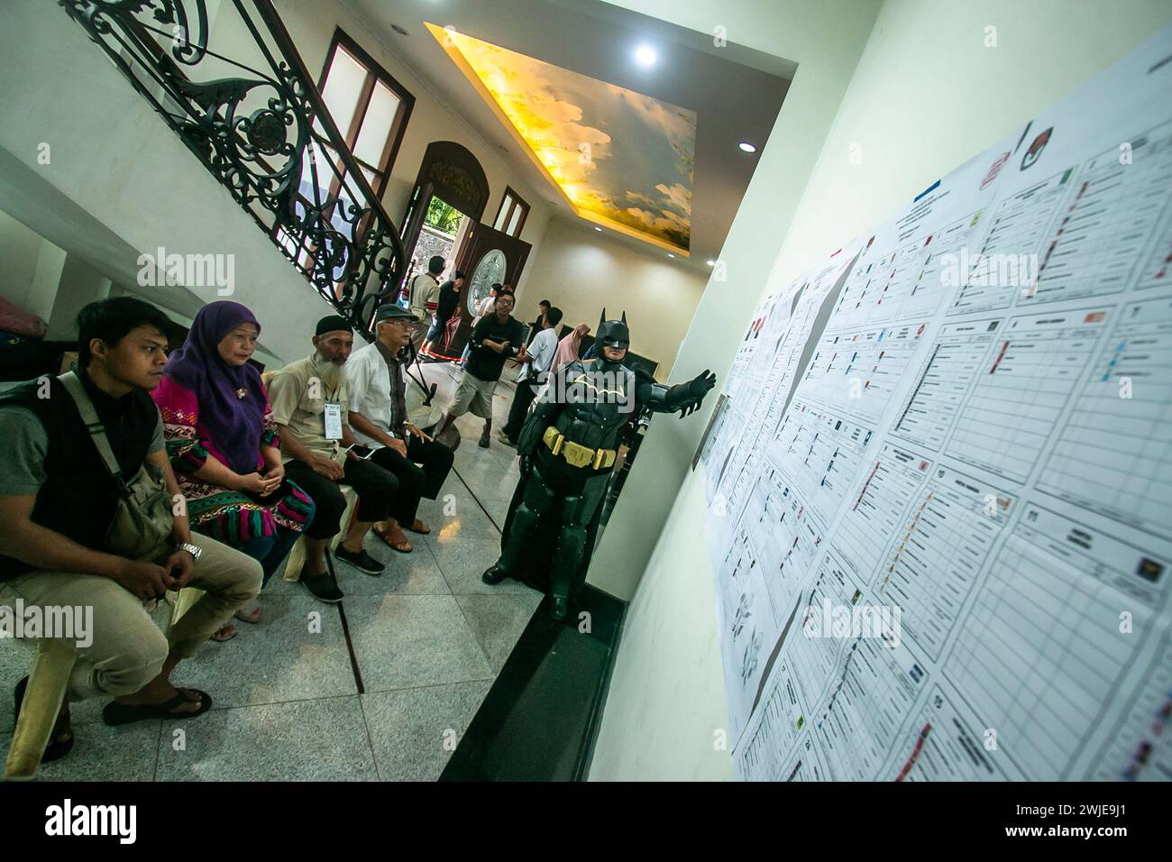 An election official wearing a Batman costume works during Indonesia presidential at a polling station in Bogor, Indonesia on February 14, 2024 Stock Photo