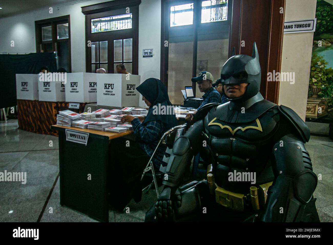 An election official wearing a Batman costume works during Indonesia presidential at a polling station in Bogor, Indonesia on February 14, 2024 Stock Photo