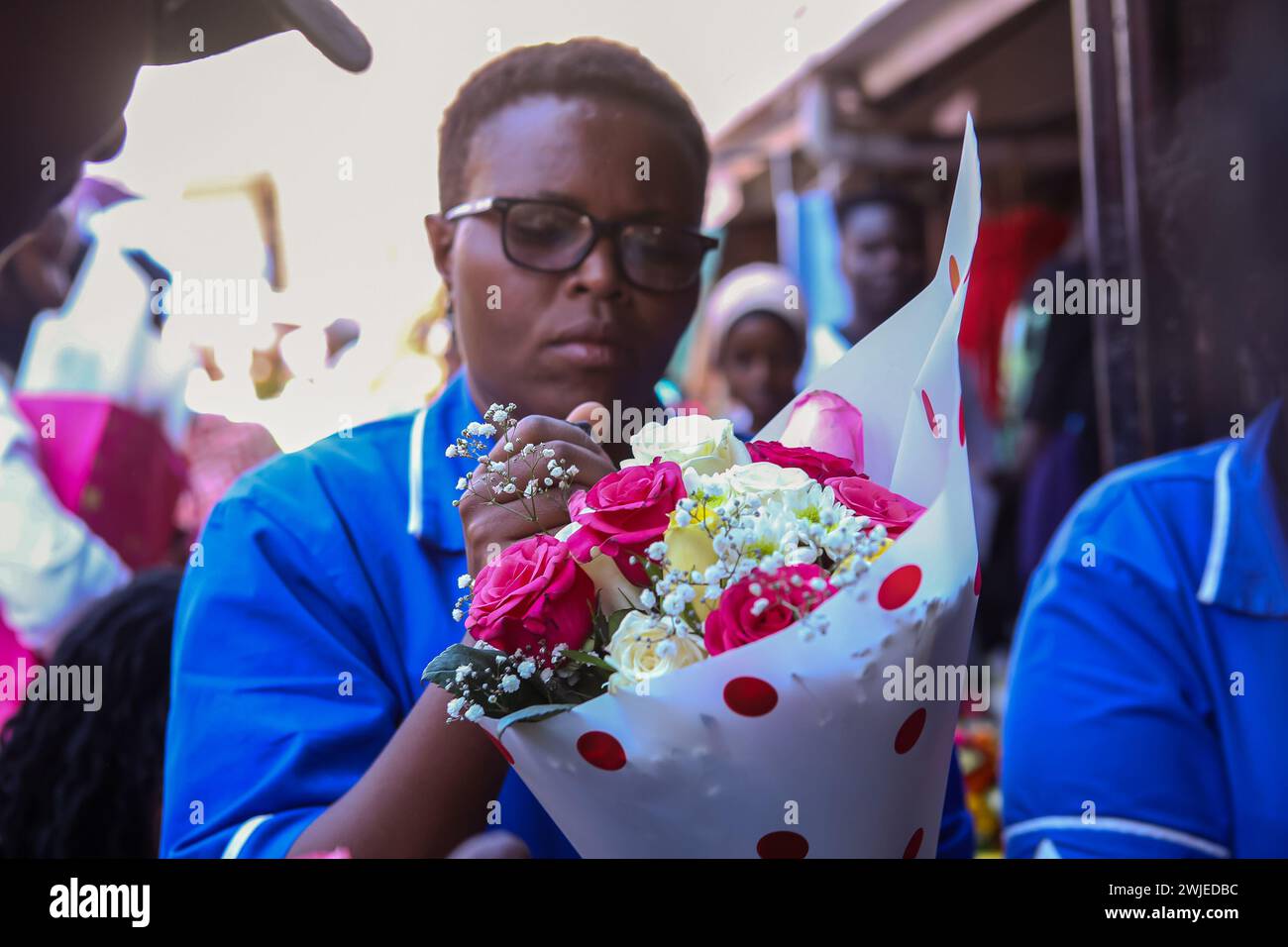 A Kenyan women puts final touches on a bouquet of flowers at the