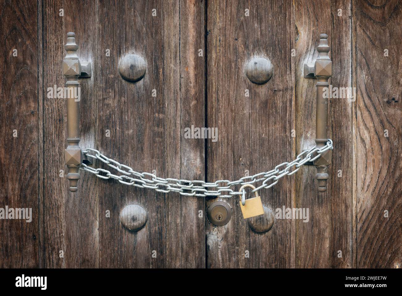 Ancient door closed by a padlocked bolt Stock Photo