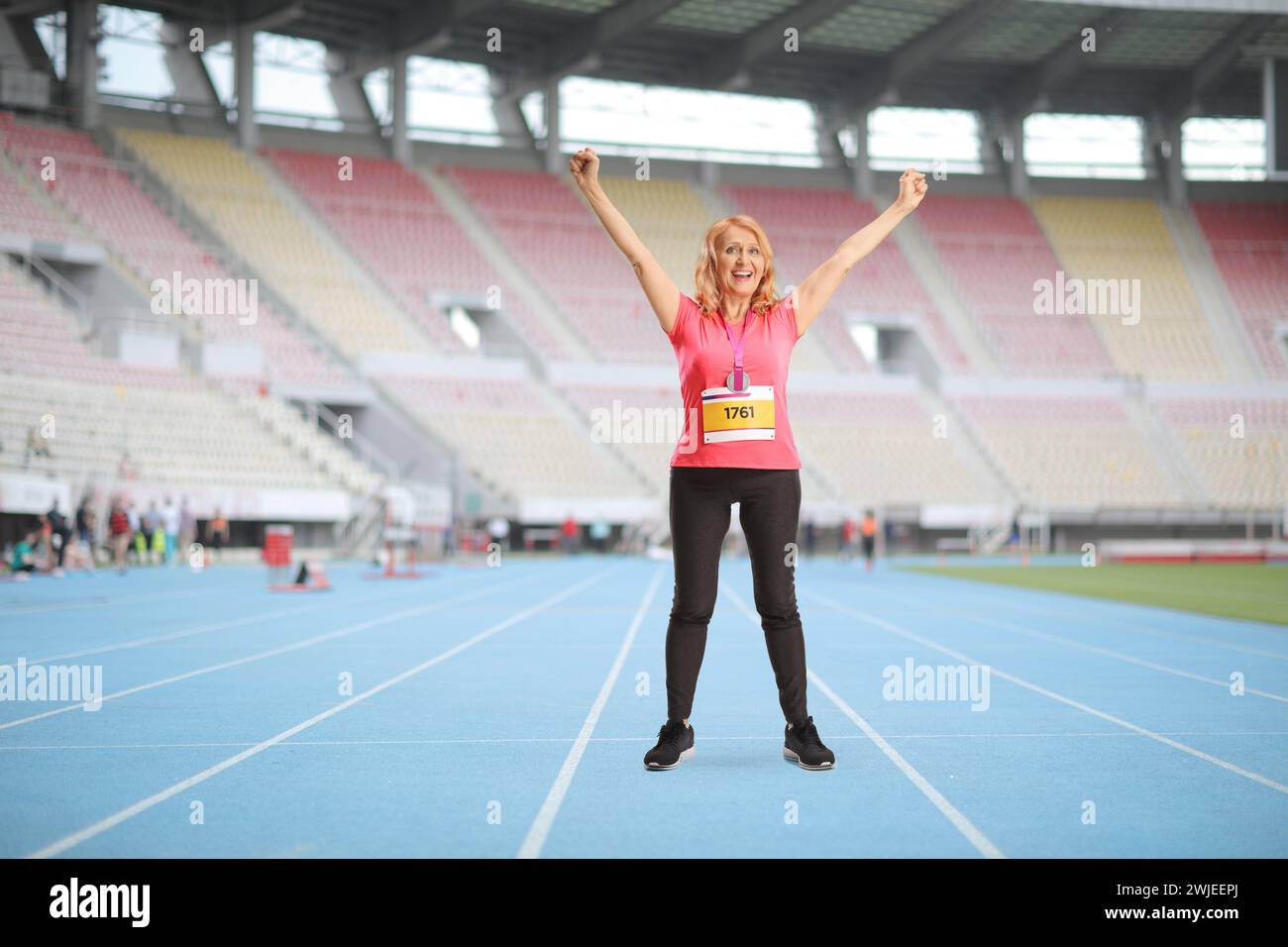 Full length portrait of a mature female runner celebrating victory at a sports stadium Stock Photo