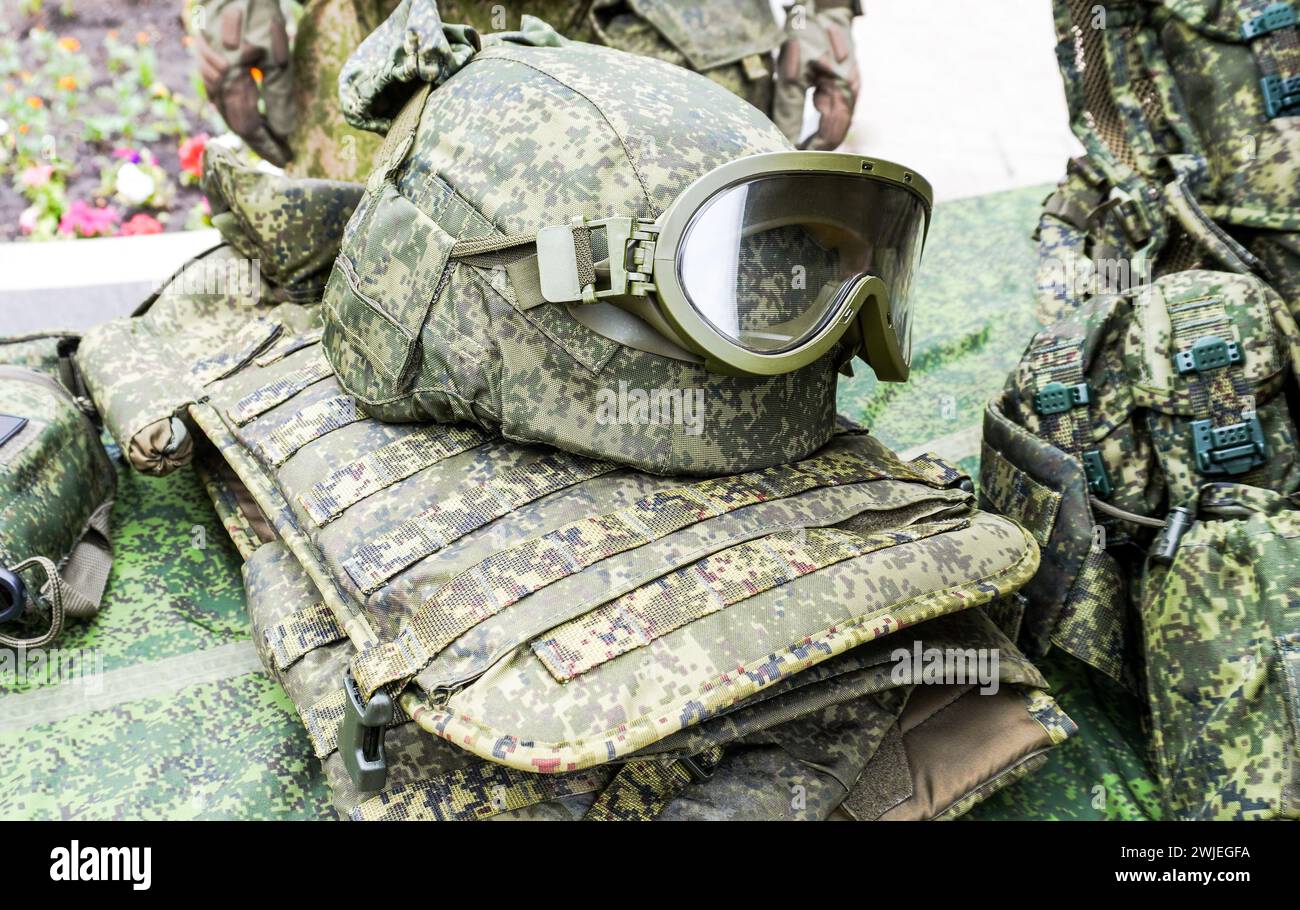Army kevlar helmet to protect the head from bullets and shrapnel with  protective goggles and camouflage cover Stock Photo - Alamy