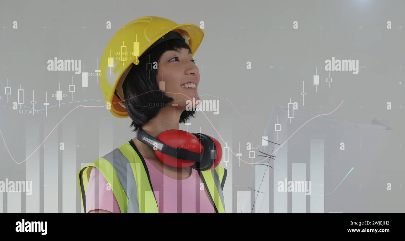 Asian female foreman with building plan and foreground graphs Stock Photo
