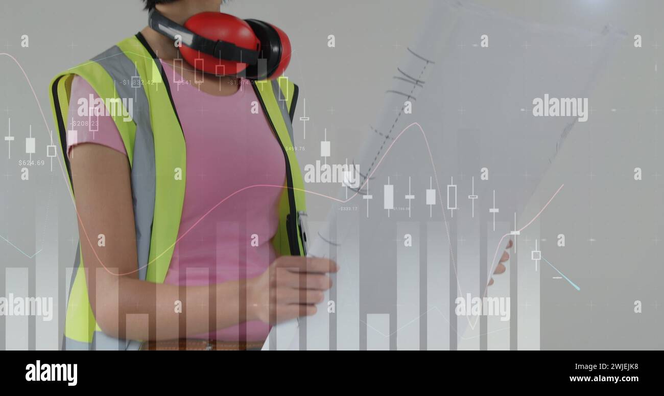 Asian female foreman with building plan and foreground graphs Stock Photo