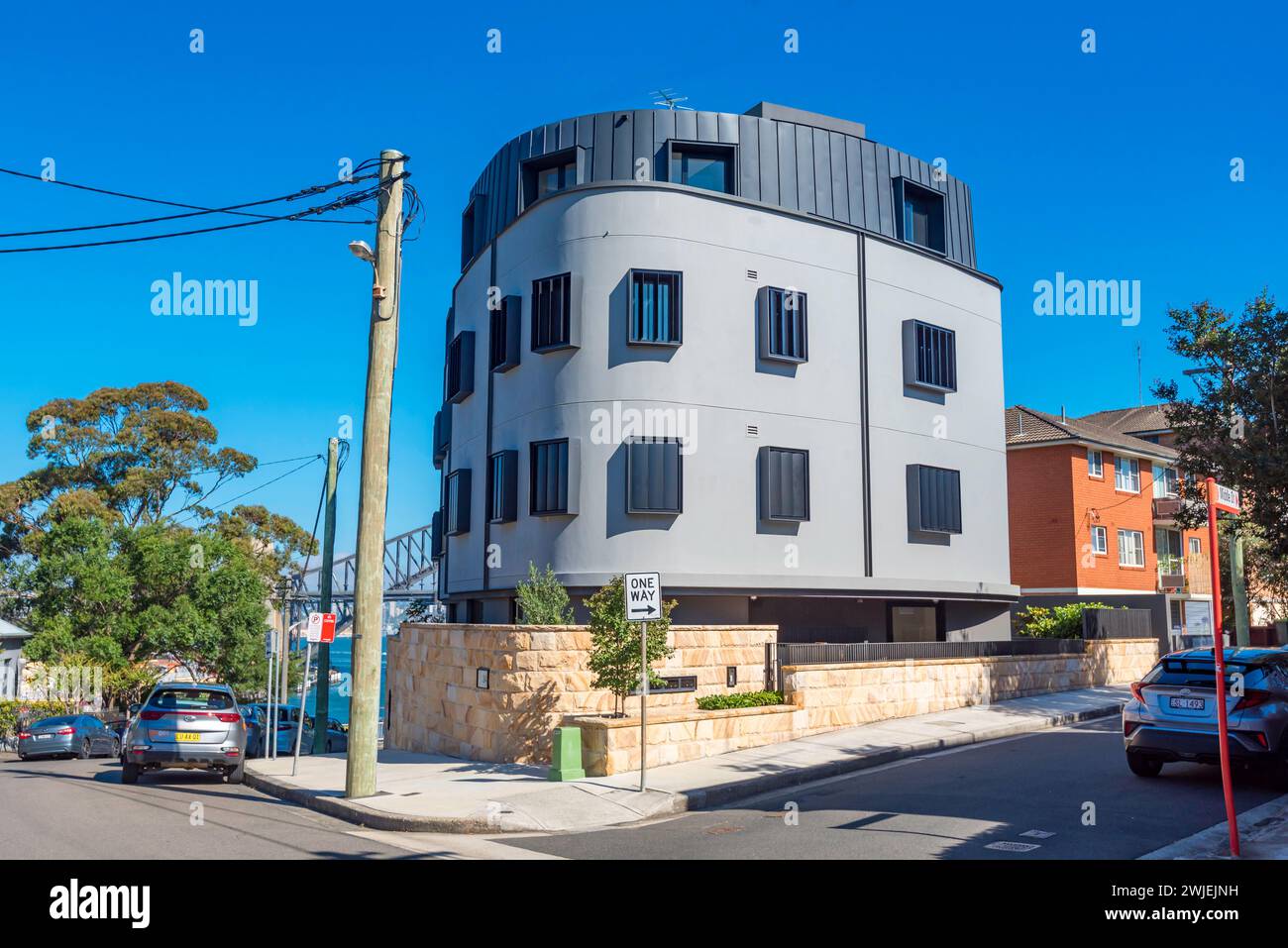 With The Sydney Harbour Bridge in the background, this modern designed apartment block stands out among the nearby older buildings in McMahons Point Stock Photo