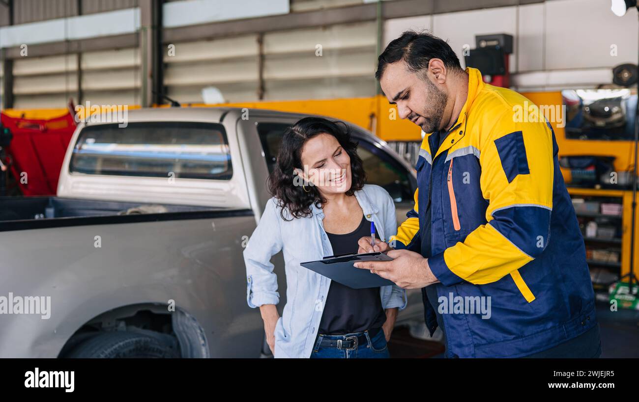 Customer women happy enjoy with mechanic worker car service check list in auto center workshop Stock Photo