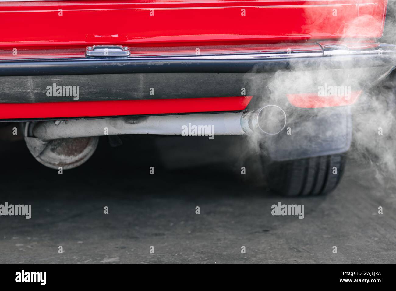 closeup old car rear exhaust pipe with smell smoke carbon monoxide bad air pollution lung disease Stock Photo