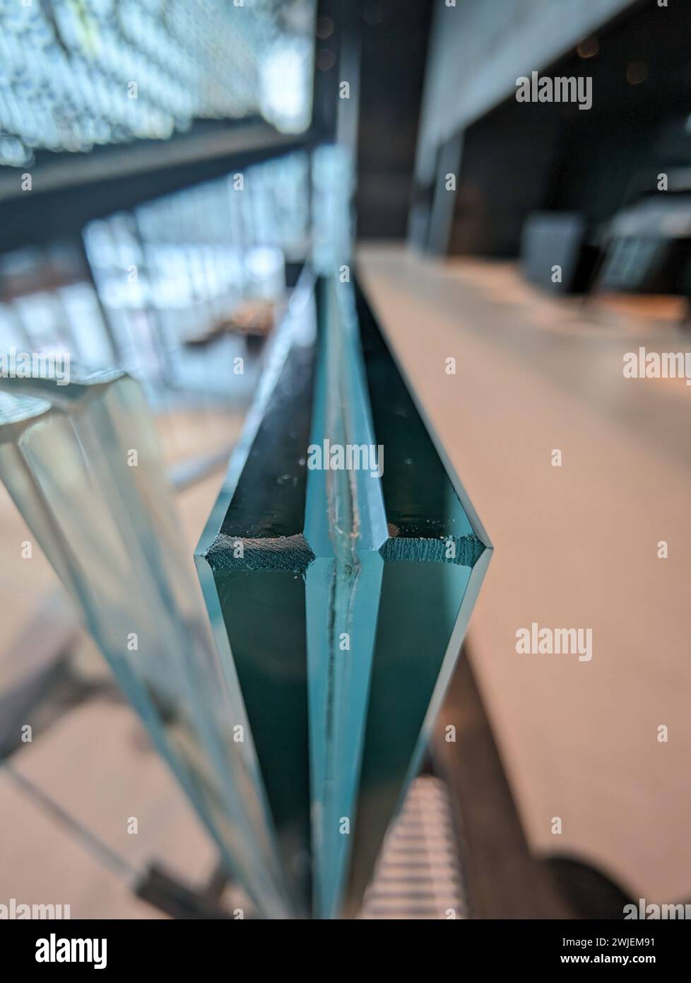 Green and transparent glass railing in a room with expansive windows ...
