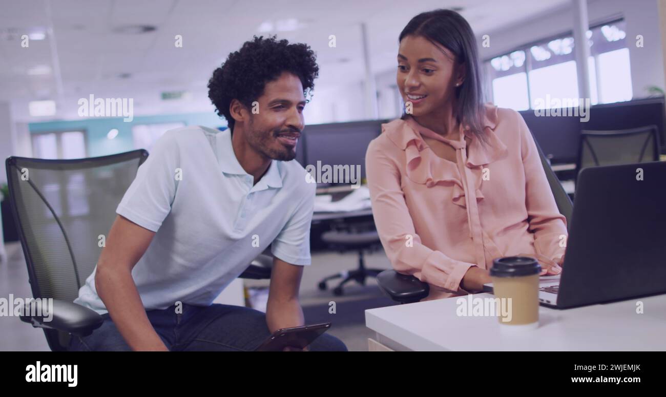 Biracial couple collaborates in a modern office setting Stock Photo