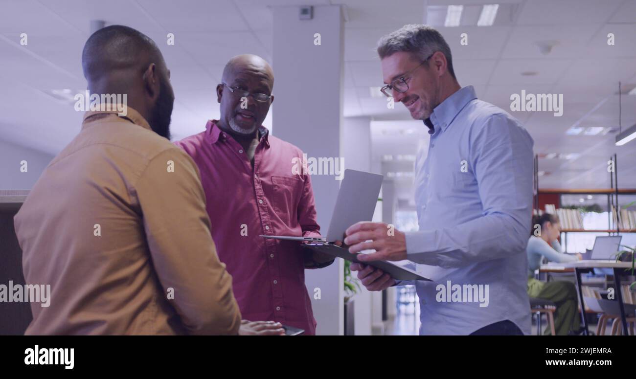 Senior African American man discusses with colleagues in an office Stock Photo