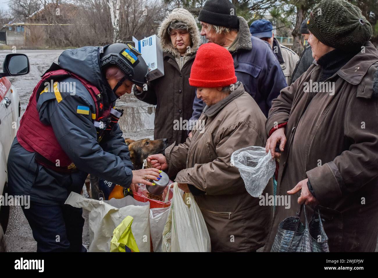 Orikhiv, Ukraine. 13th Feb, 2024. Local residents receive pet's food for dogs and cats at a humanitarian aid distribution spot in Orikhiv. Orikhiv is a small town near Zaporizhzhia, which serves as the last pillar of resistance for Ukrainian army soldiers in the south, as Russian armed forces continue to advance to the liberated Robotyne. Home to around 700 people, Orikhiv's citizens risk their lives enduring the daily air bomb and artillery attacks as they struggle to survive. Credit: SOPA Images Limited/Alamy Live News Stock Photo