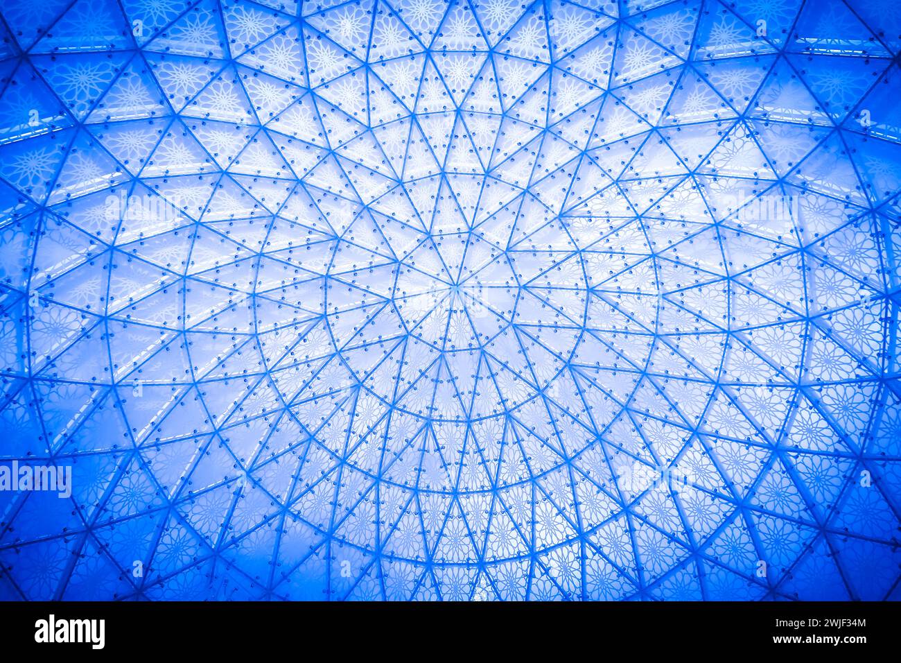 Glass ceiling in blue sky sunlight abstract. Glass roof of the building. Geometrical ceiling, limpid round ceiling. Geometrical dome made of glass. Sk Stock Photo