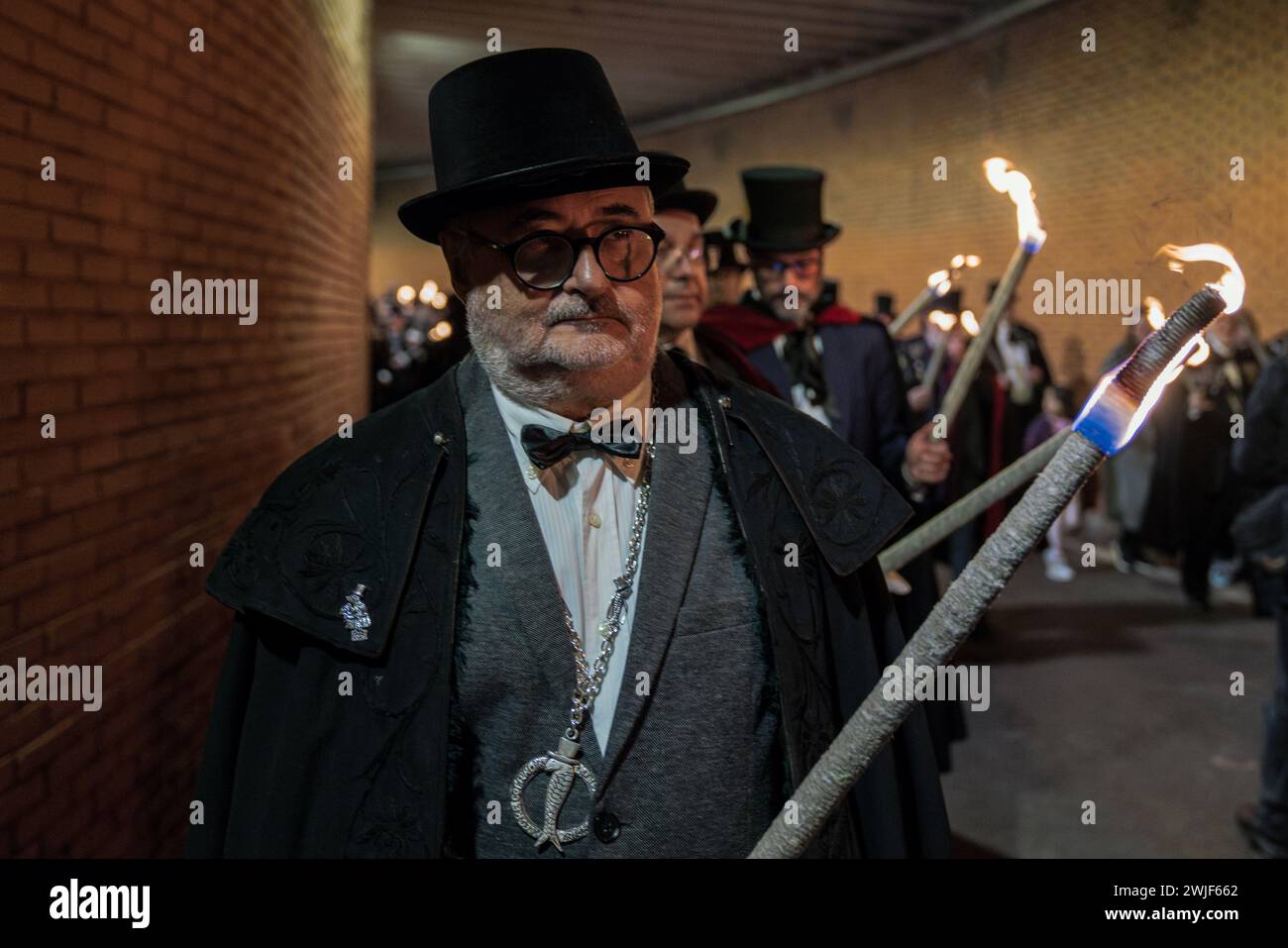 A member of the brotherhood of the sardine is seen carrying a torche lighting during the procession. The Sardine procession which takes place in Madrid, is a centuries-old Spanish tradition made famous by a painting of the Spanish artist Francisco de Goya called The Burial of the Sardine. It marks the end of Carnival celebrations and the beginning of Lent 40 days before Easter. It consists of a procession that parodies a funeral in which a symbolic figure of a sardine in its coffin is burned. The festivity takes place every Ash Wednesday and symbolizes the burial of the past and the rebirth of Stock Photo