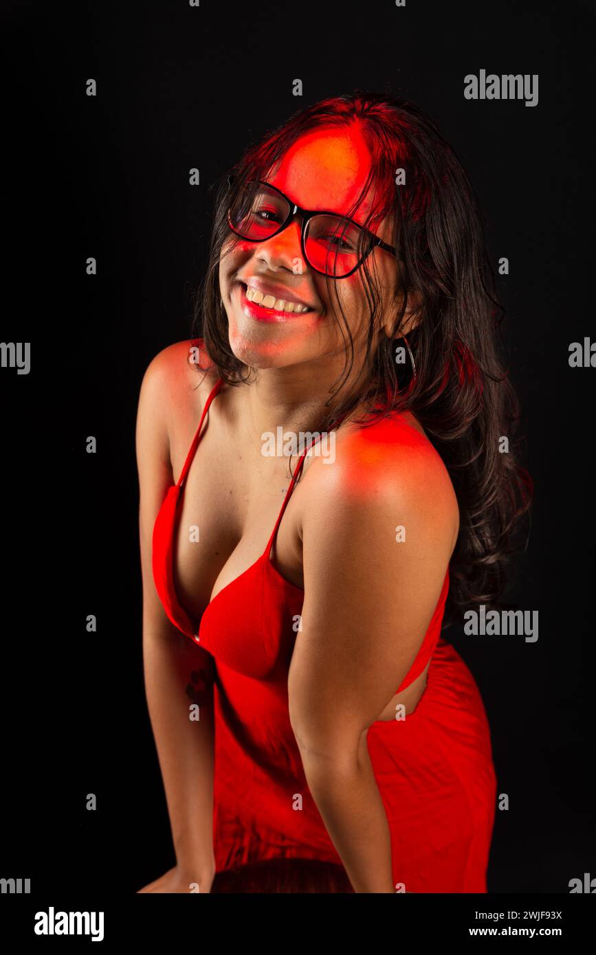 Salvador, bahia, Brazil - December 09, 2023: Beautiful young woman wearing prescription glasses wearing red clothes and posing for a photo. Isolated o Stock Photo