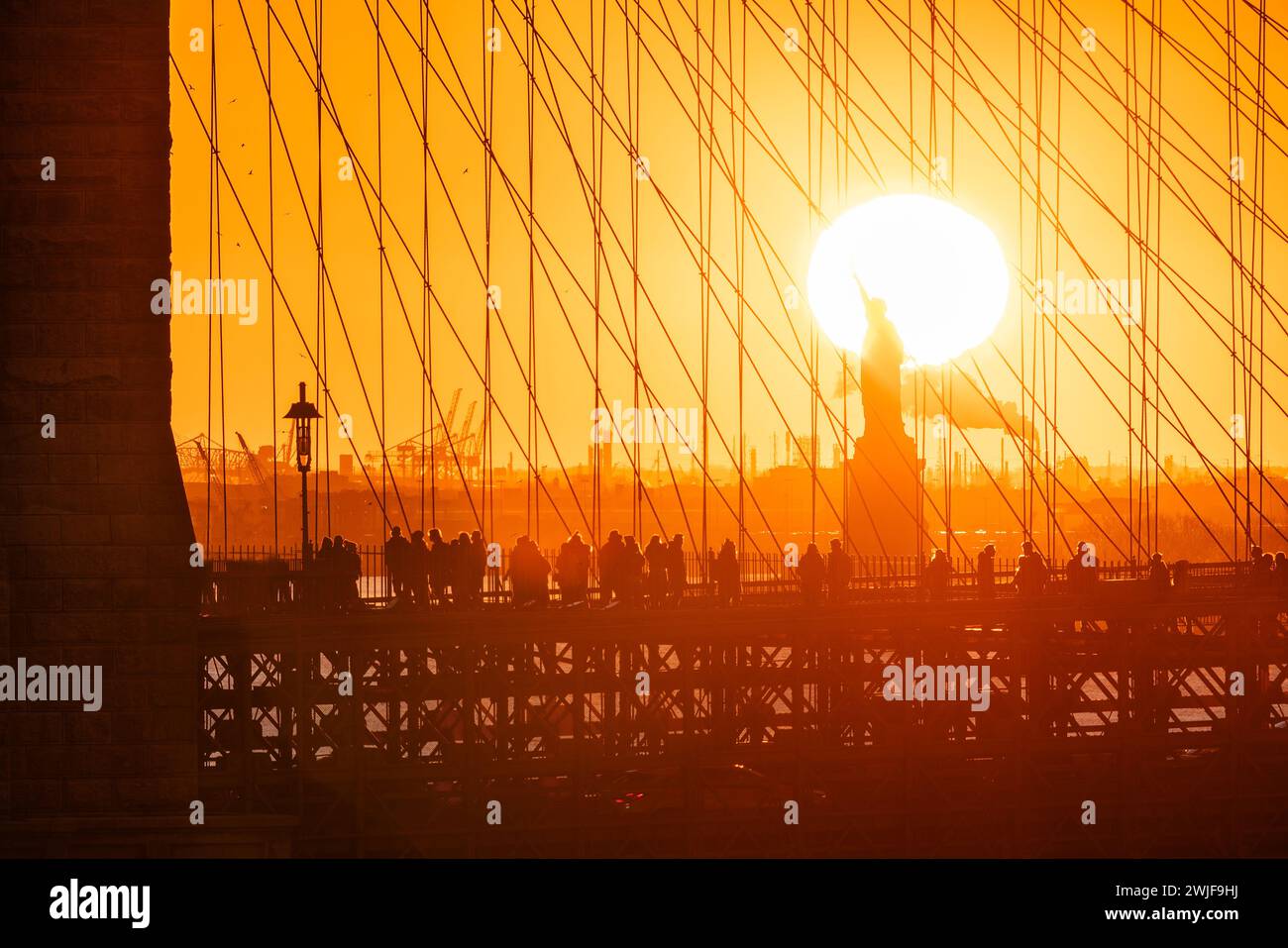 Close up views of Brooklyn Bridge and Statue of Liberty in the orange glow of sunset. New York City historic landmarks Stock Photo