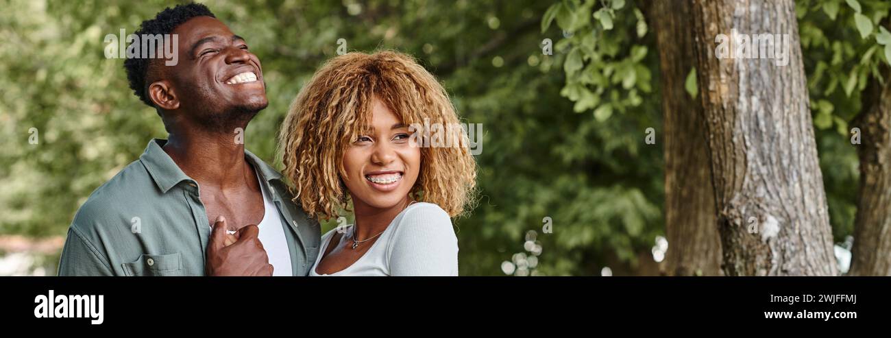 cheerful african american couple holding hands and hugging each other ...