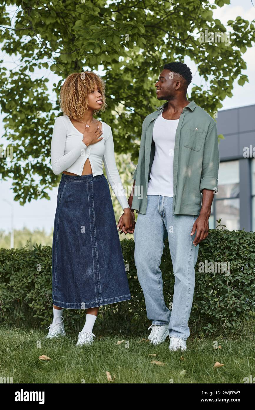 happy african american couple holding hands and communicating with ...