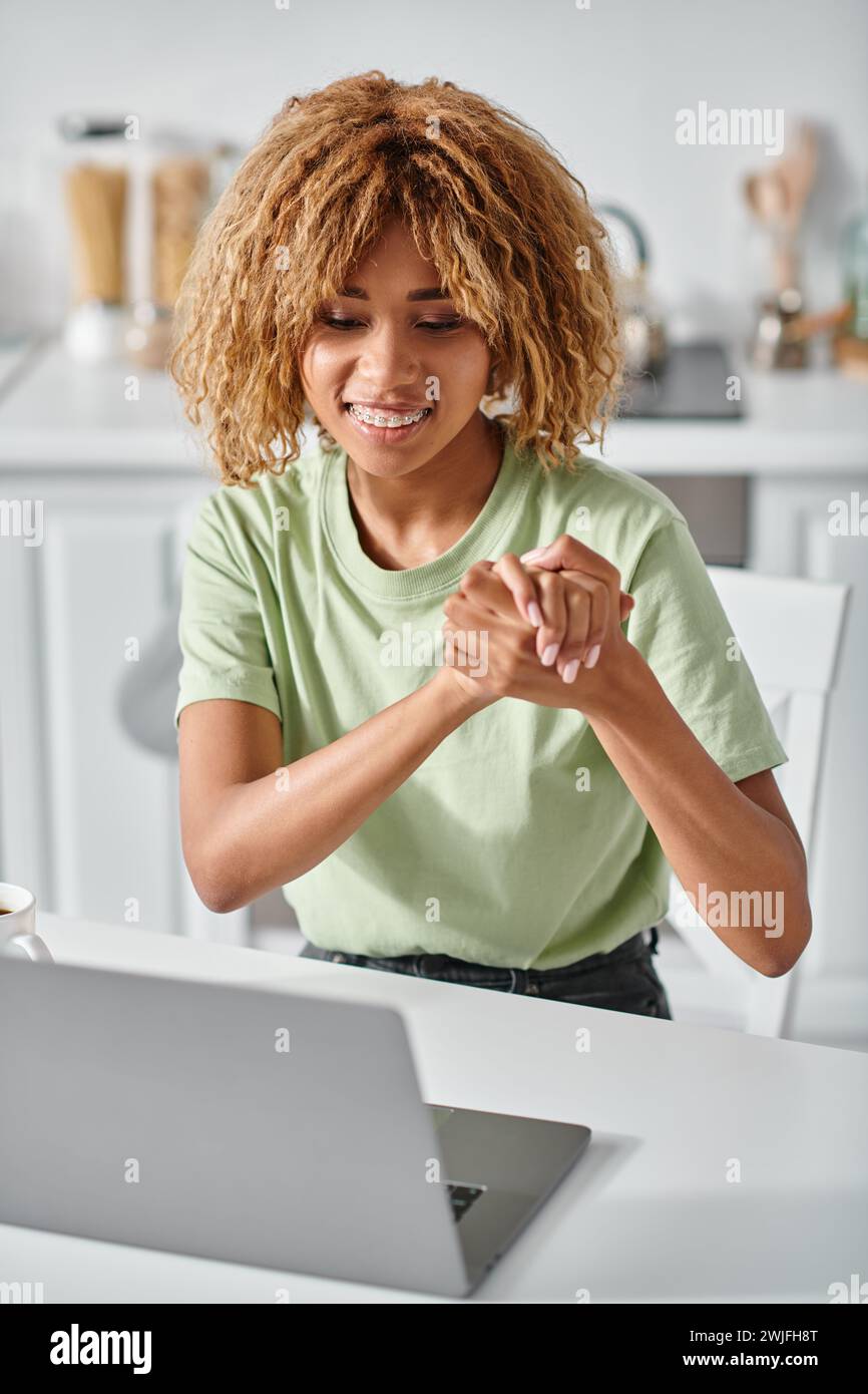 pleased african american woman in braces using sign language during
