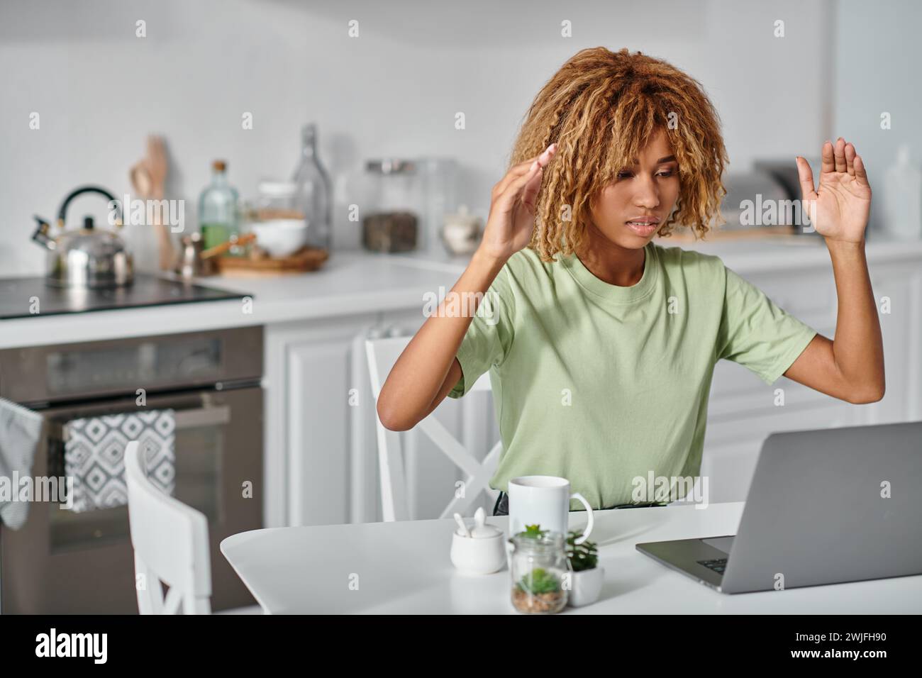 curly african american woman in braces using sign language during video