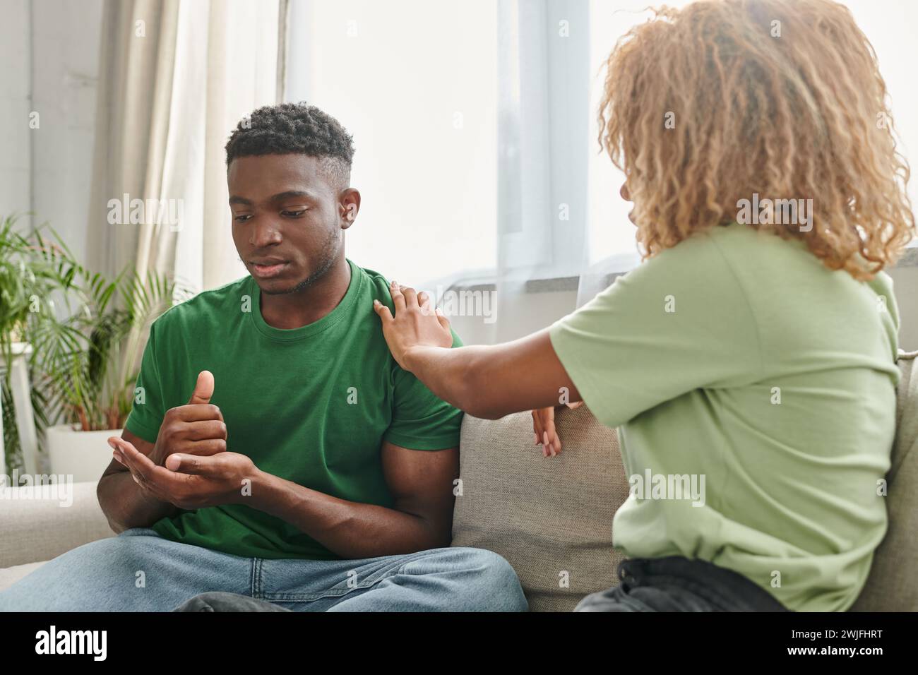 black man showing help gesture while communicating with girlfriend and using sign language Stock Photo