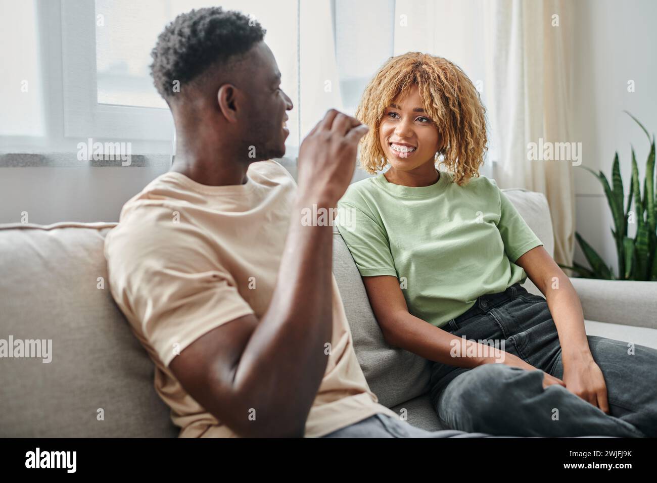 sign language, happy african american woman in braces looking at