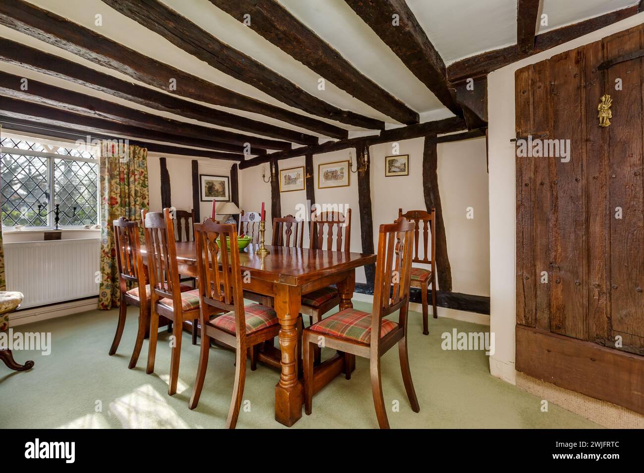 Dalham, Suffolk, England - Feb 19 2016: 16th Century english cottage dining room with exposed beams Stock Photo