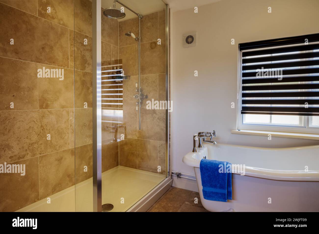 Dalham, Suffolk, England - Feb 19 2016: Compact cottage bathroom with shower and roll top bath Stock Photo
