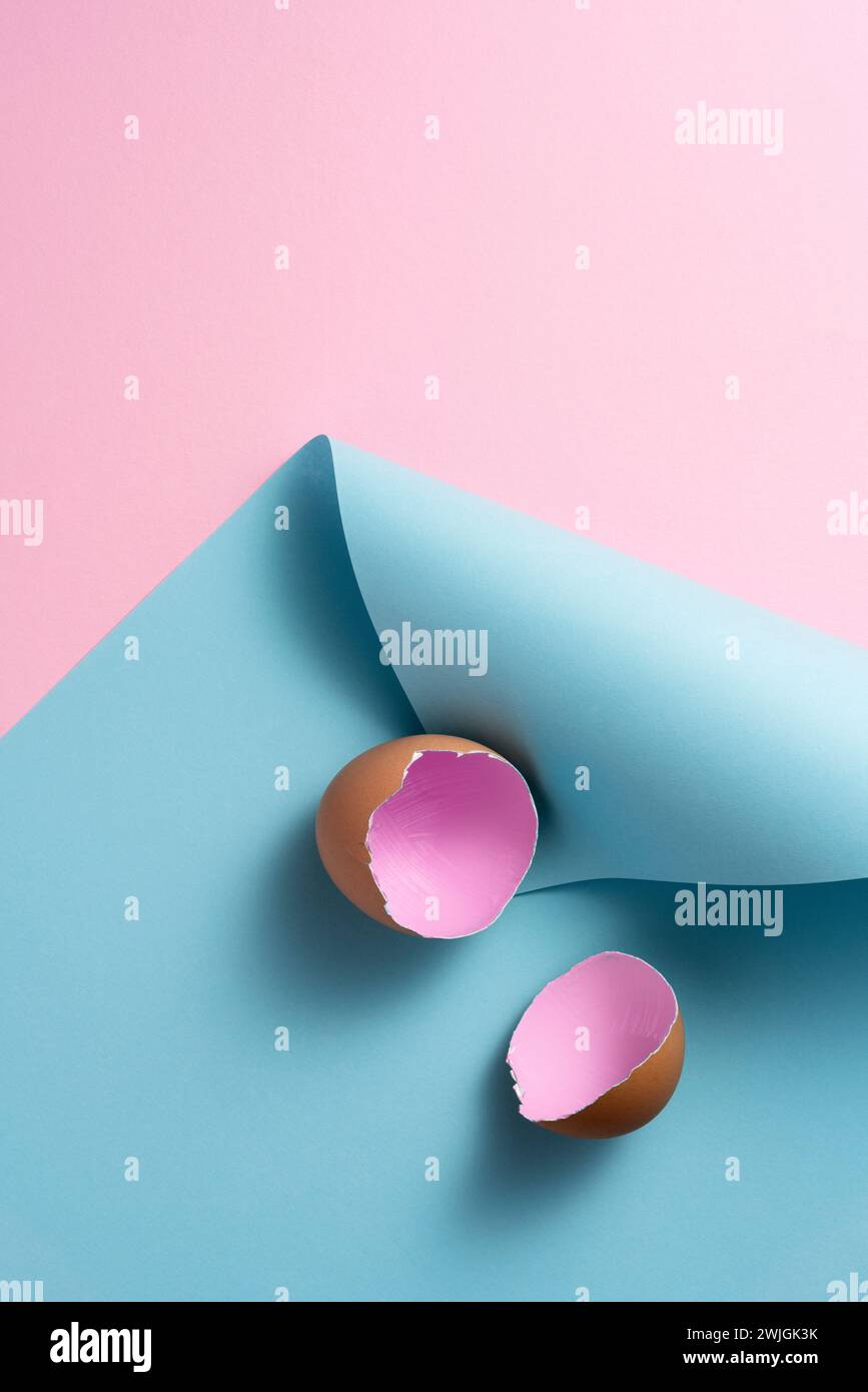 Pink painted easter egg shells on pink and blue curled paper background Stock Photo