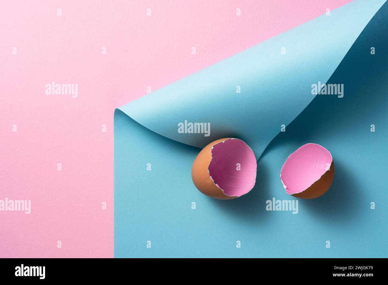 Pink painted easter egg shells on pink and blue curled paper background Stock Photo