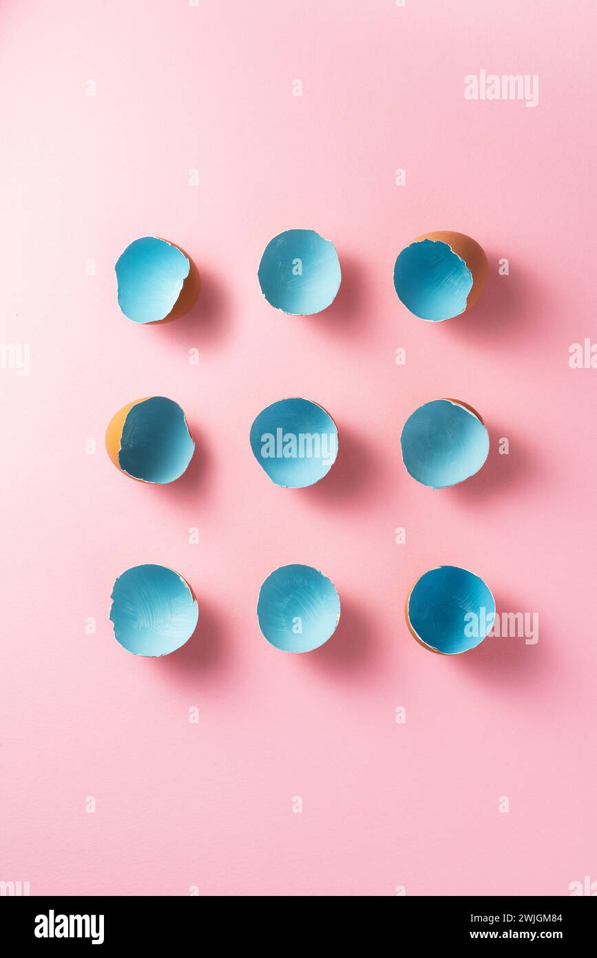 Blue painted easter egg shells on pink background, directly above shot Stock Photo